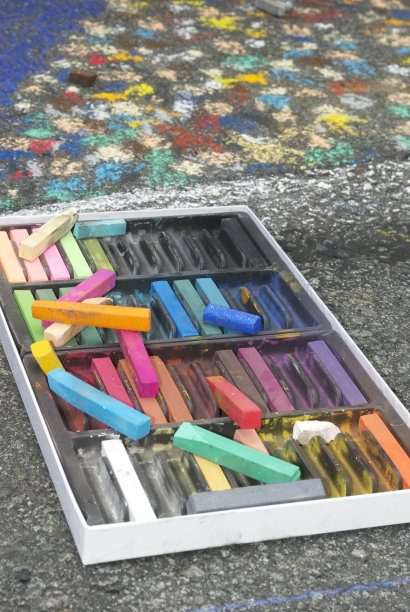 彩色蜡笔与人行道艺术在沥青上。图片下载