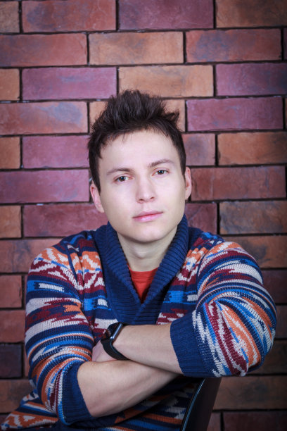 年轻英俊的男子坐在椅子上图片下载