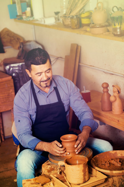 工匠在陶轮上制作陶瓷件图片下载