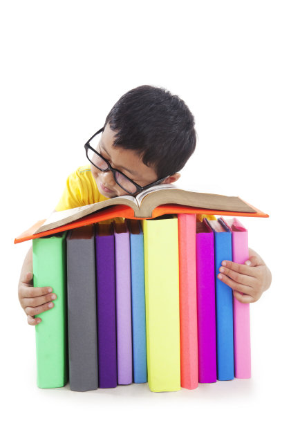 戴眼镜的男孩睡在书上图片下载