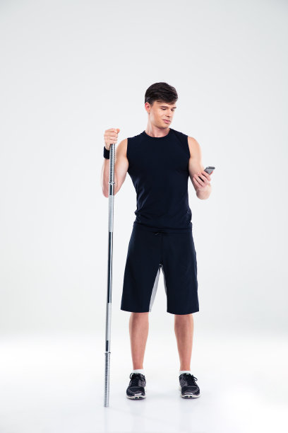 手持杠铃、使用智能手机的男子图片下载