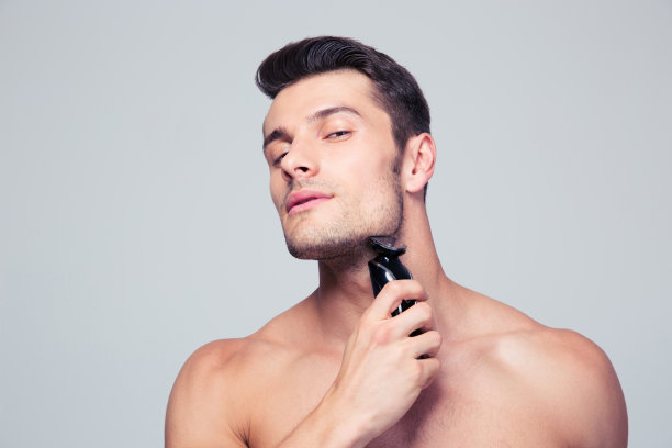 年轻人用电动剃须刀刮胡子图片下载