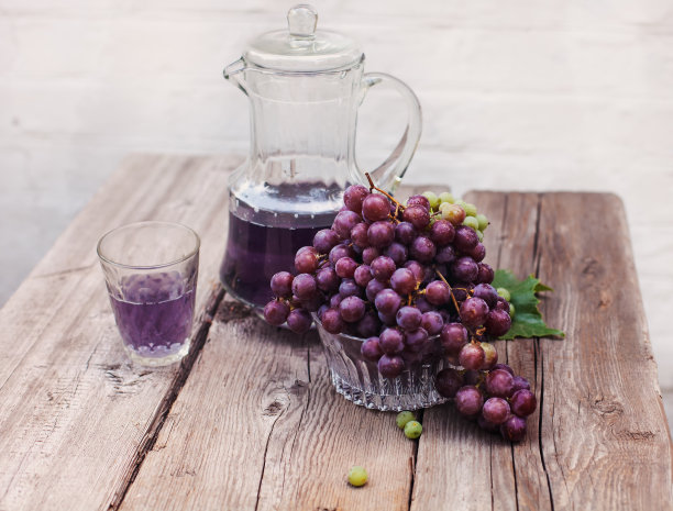 新鲜的绿色和蓝色的葡萄。一瓶葡萄汁图片下载