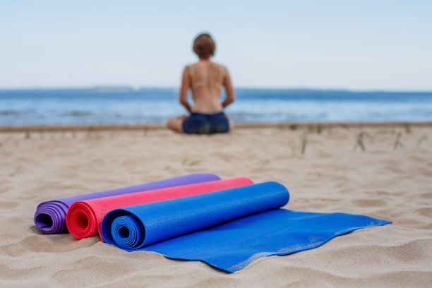 等待学生——瑜伽垫躺在沙滩上图片下载