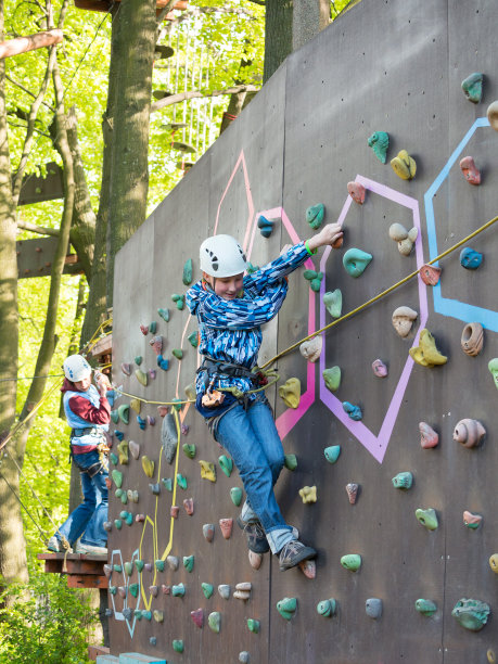 母子戴着安全帽，带着安全带爬墙图片下载