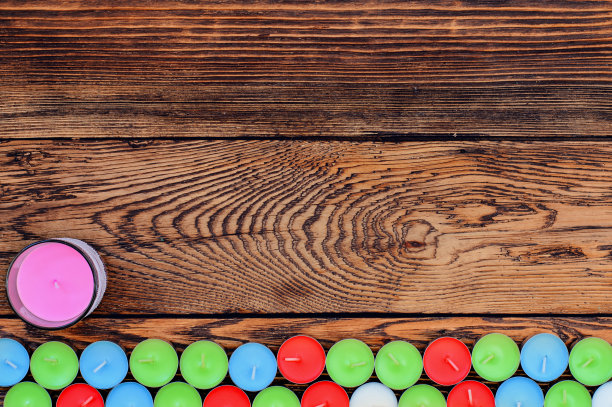 木桌上放着不同颜色的蜡烛图片下载