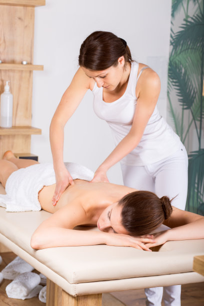 年轻漂亮的女士正在做背部按摩图片下载