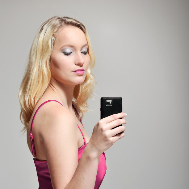 女人在操作她的智能手机。图片下载