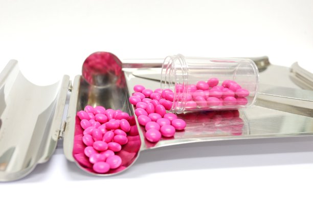 在药房柜台托盘里的粉色药片图片下载