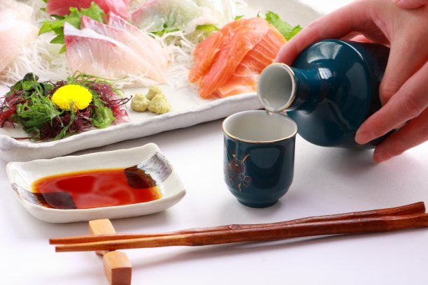 倒入日本米酒、清酒和什锦生鱼片，日本料理图片下载