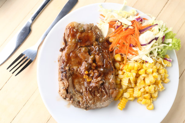 牛扒放在白盘子上，木板做背景。图片下载