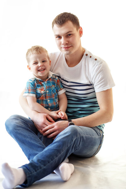 快乐的父亲和儿子享受自己在白色的背景图片下载