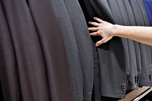 男人的手挑选西装外套在商店图片下载