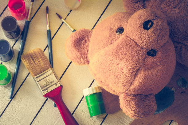 泰迪熊躺在木制的背景上，涂着蛋彩画图片下载