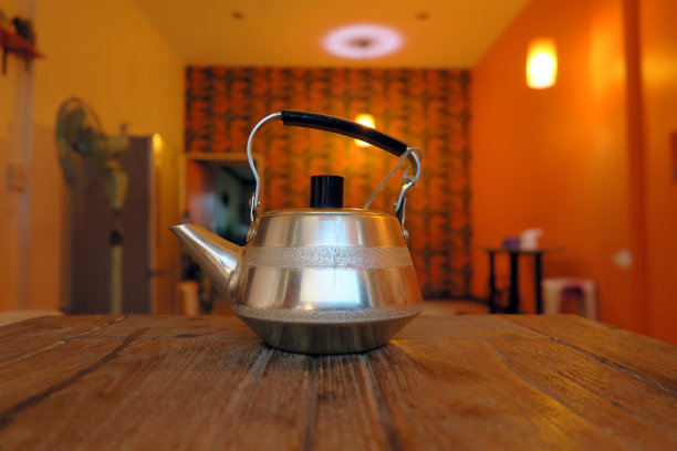 木制桌子上放着用过的铝茶壶。图片下载