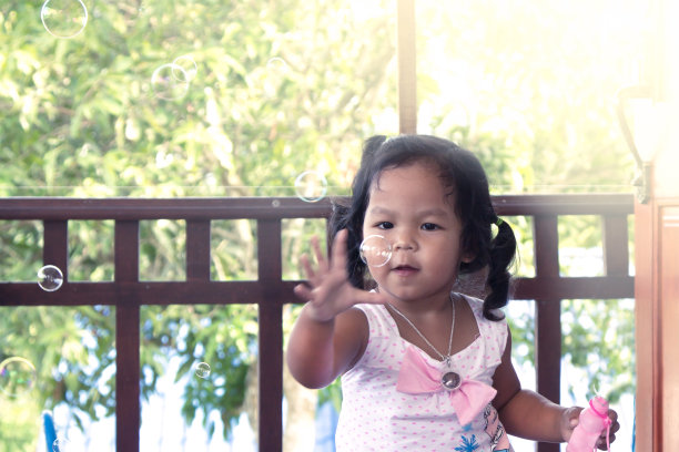 可爱的小女孩玩泡泡玩得很开心图片下载