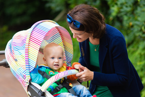 年轻的母亲和她的婴儿在婴儿车里图片下载