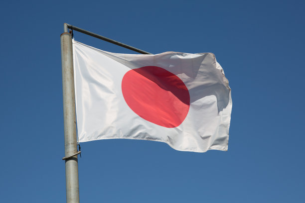 国家日本国旗在风中飘扬，背景是蓝天图片下载