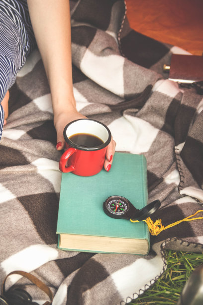 咖啡杯和书在绿色的草地在夏天图片下载