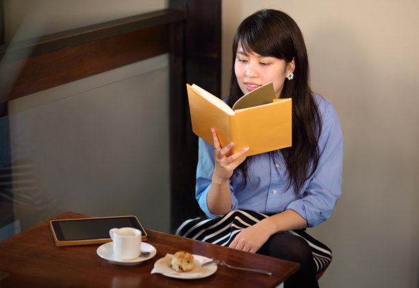 一个年轻女子在咖啡馆里看书图片下载