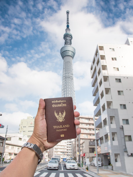 左手拿着泰国护照，背景模糊的Toky图片下载