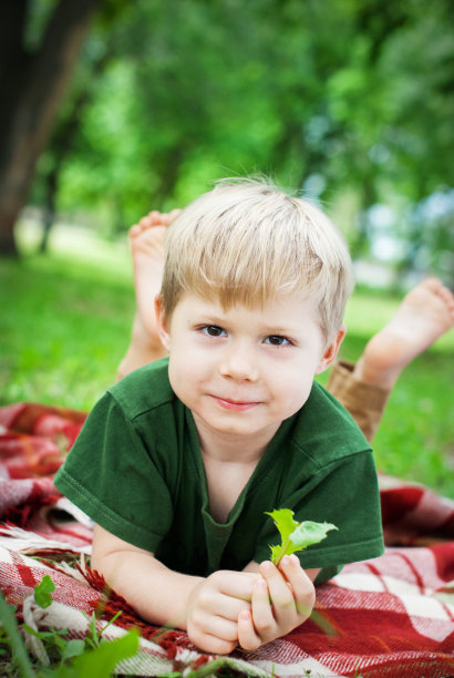 光着脚的孩子躺在野餐格子上图片下载