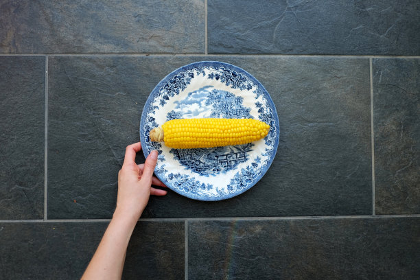手里拿着盘子里的玉米图片下载