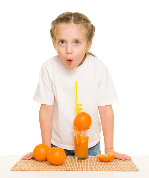 拿着橘子的小女孩用吸管喝果汁图片下载