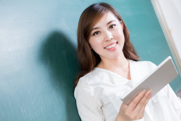 亚洲美女拿着写字板在黑板前图片下载