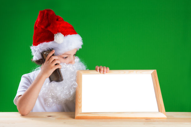 小圣诞老人看着一个空的相框图片下载