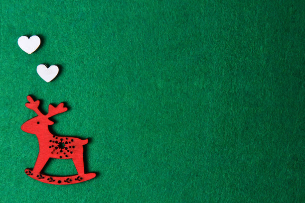 红色圣诞鹿雕刻椅子上的绿色背景，木制图片下载