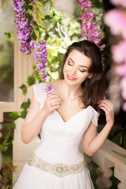 穿白裙子的美女。新娘，微笑婚礼在花园。浅黑肤色的女人图片下载