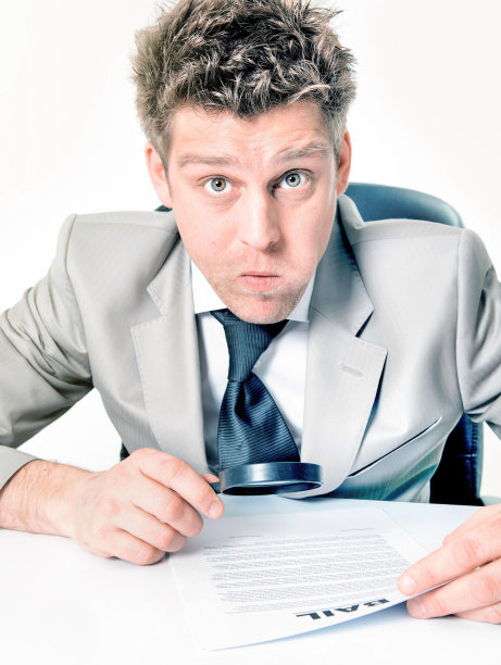 有表现力的商人用放大镜分析合同图片下载