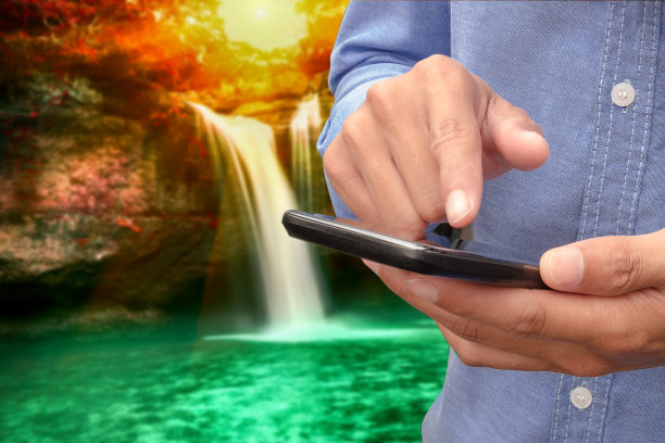 手拿智能手机看模糊的休苏瓦特瀑布图片下载