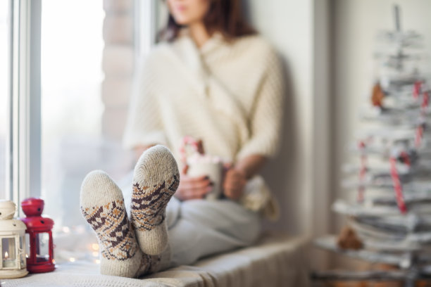 年轻漂亮的女人在圣诞节装饰窗台上休息图片下载