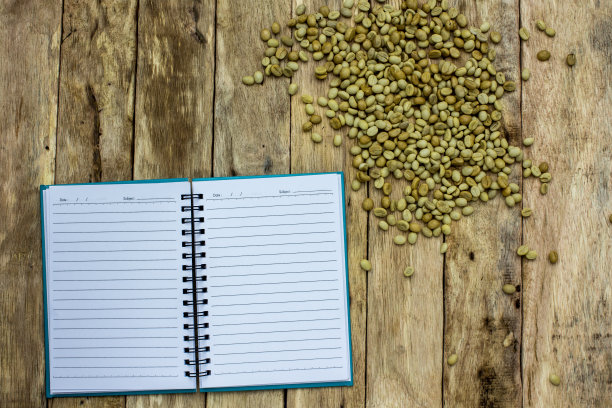 咖啡豆在笔记本上。图片下载