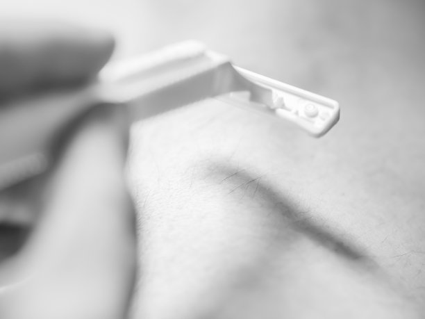 特写毛腿剃须与手和剃须刀。图片下载