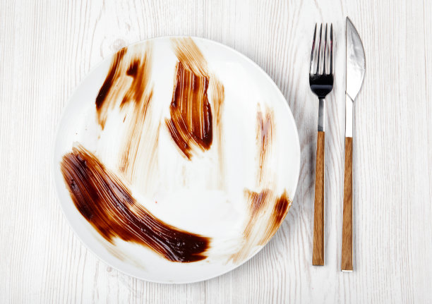 舔着一盘白色的巧克力甜点。空板。dishwa图片下载