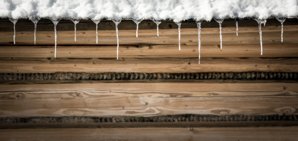 一排排的冰柱悬挂在带有复制空间的木质立面上图片下载