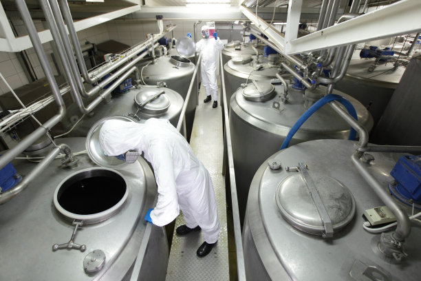 两名技术人员与工厂的工业工艺槽一起工作图片下载