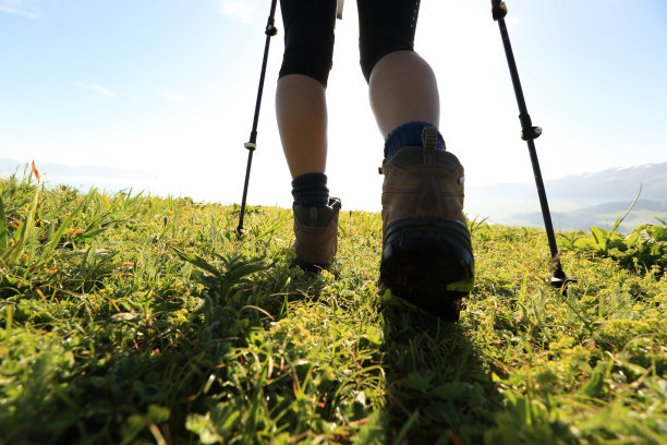成功的女性徒步旅行者腿登山在山顶图片下载