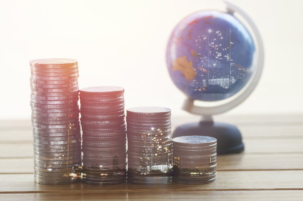 桌上放着一堆硬币和地球仪图片下载