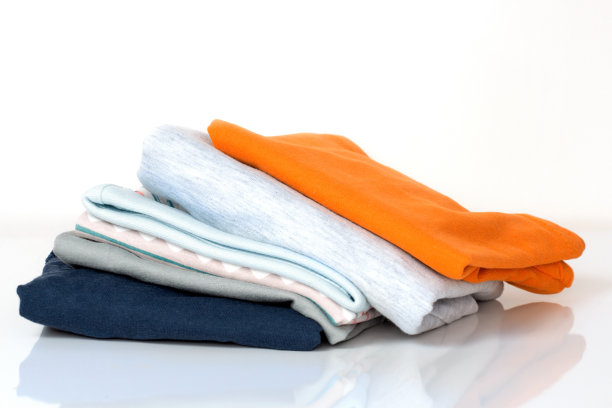 把叠好的棉质衣服叠在白色的衣服上。图片下载