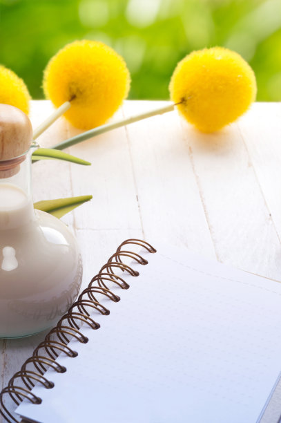 空白笔记本和牛奶瓶与绿色抽象背景图片下载