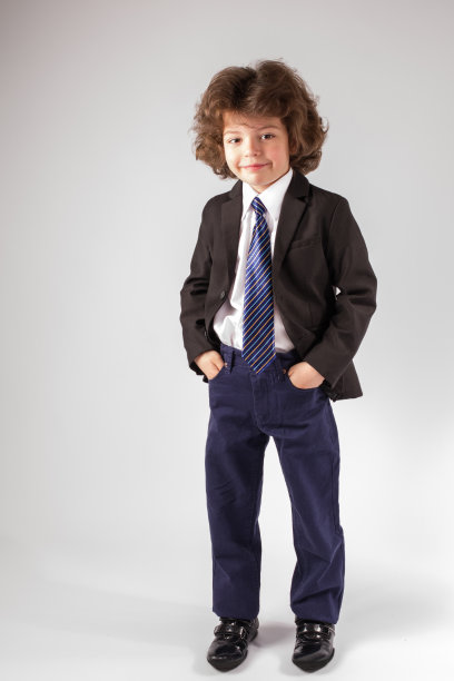 卷毛可爱的男孩站在那里看着镜头图片下载