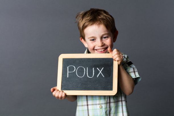 傻笑的男孩拿着石板对抗法国的“poux”或头虱图片下载