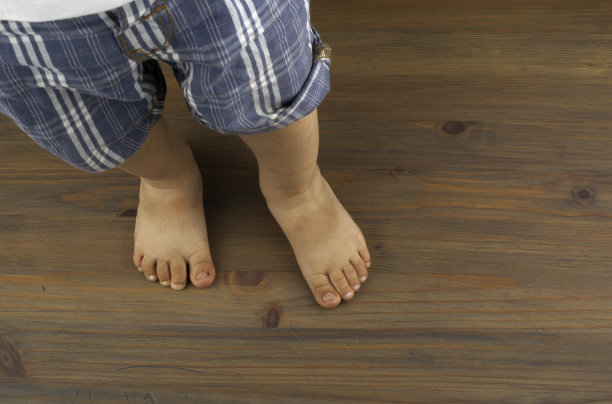 孩子的脚踩在木地板上图片下载