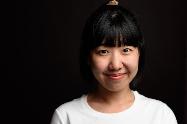 年轻的亚洲女孩微笑在黑色的背景图片下载