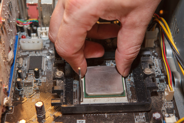 维修工把CPU插入主板上的插座。关闭图片下载