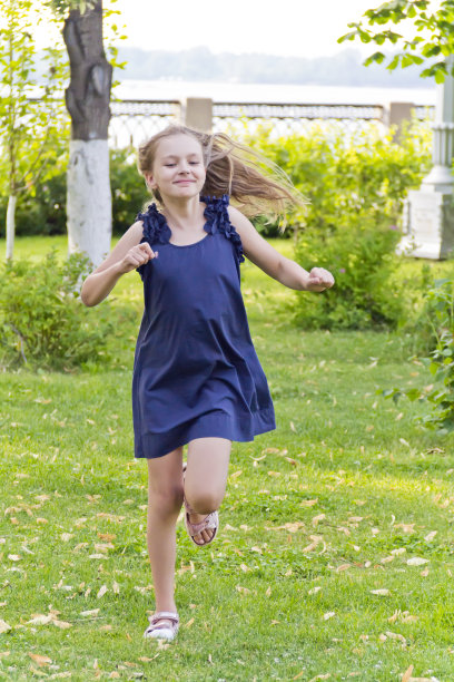 披头散发的女孩在绿色的公园里奔跑图片下载